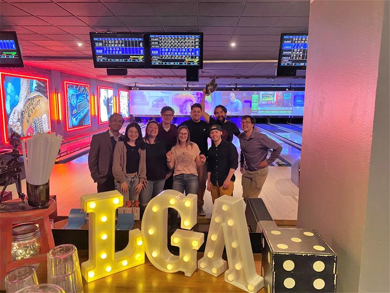 LGRA employees smiling in a group shot at employee bowling event in front of bowling lanes
