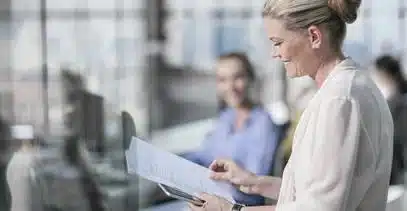 Smiling business woman in office reviewing a report