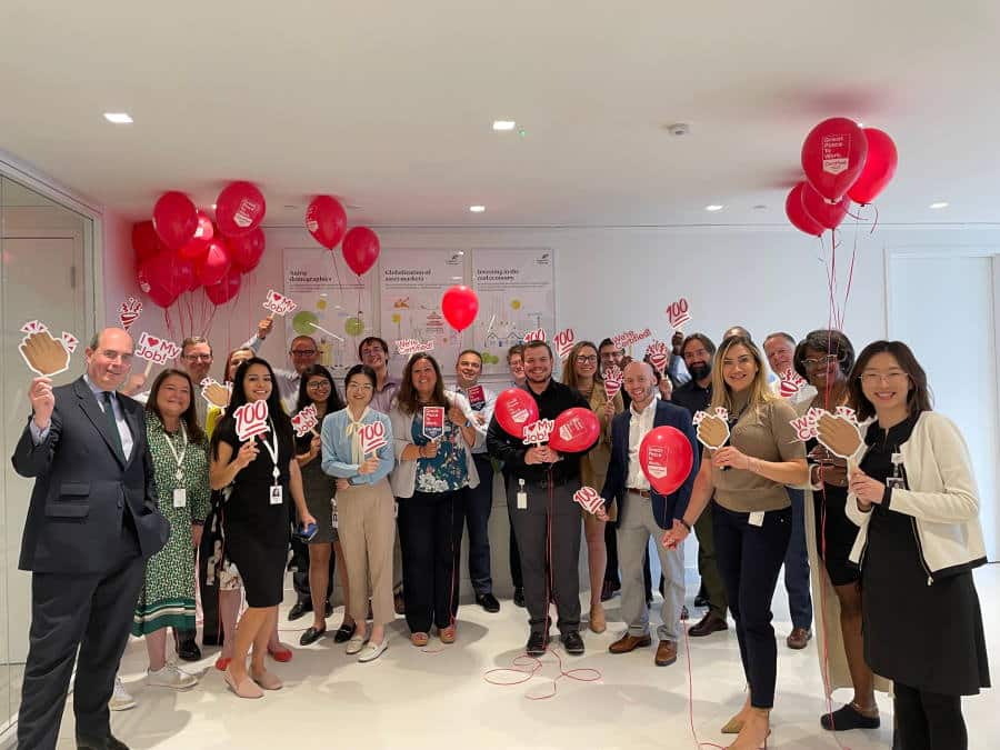 A group of LGRA employees celebrating with fun signs and balloons Great Place to work award